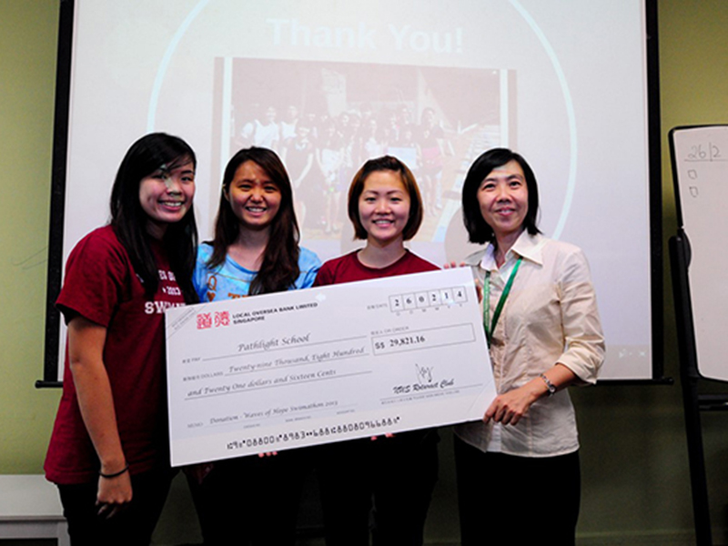Dr Christine Koh (right), Deputy Track Head (Secondary) of Pathlight School, receiving the cheque from representatives of NUS Rotaract Club
