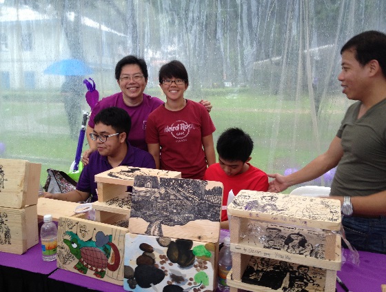 Pathlight School Vice-Principal Ms Loy Sheau Mei (left, standing) with ADP student artists and their art stools at the Purple Parade