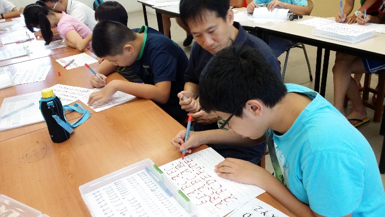 Students working on their calligraphy skills with instructor