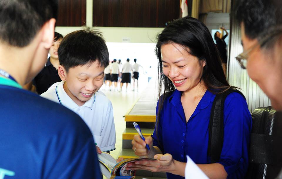 Ms Kam Ning signing an autograph for a student